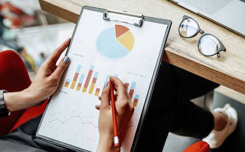 Woman working on a pie chart printed on an A4 paper