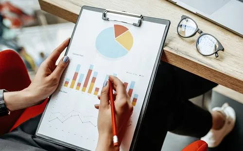 Woman working on a pie chart printed on an A4 paper