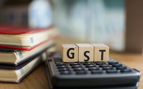 calculator with blocks on top spelling the word "GST"